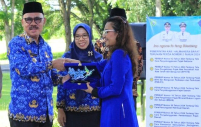 
 Bupati James Uang di dampingi Kepala Bapenda Chuzaemah Djauhar menyerahkan cendramata kepada Kepala Bank Maluku-Malut sebagai media kerjasama dalam mensukseskan launching aplikasi E-payment. Foto: OpsiNews).