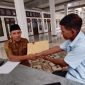 Ketua BPD menyerahkan laporan ke salah satu staf DPMPD Kabupaten (foto: OpsiNews/WK001).
