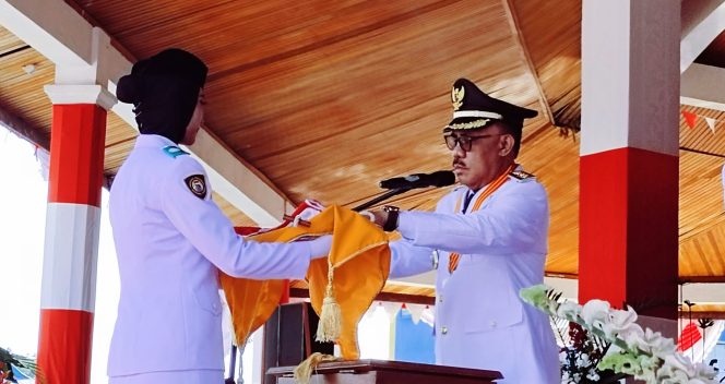 
 Bupati Kabupaten Halmahera Barat, James Uang menyerahkan bendera merah putih kepada Paskibraka 